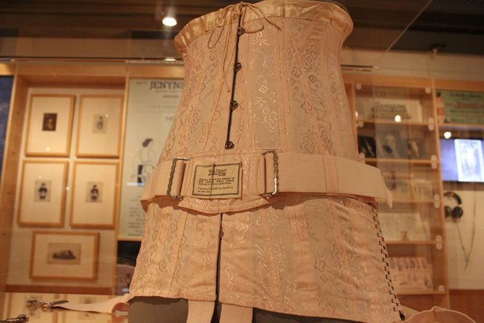 A pink corset on a mannequin torso in the State Library of Queensland.